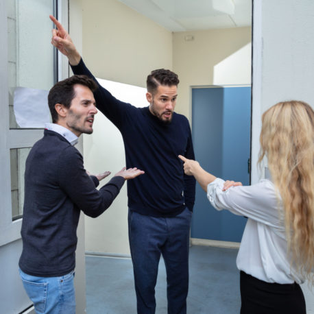 Rear View Of A Couple Quarreling With Man Standing Outside The Door